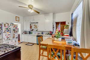 Kitchen featuring white cabinetry, ceiling fan, and white appliances