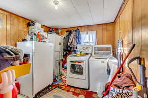 Clothes washing area with washer and clothes dryer and wooden walls