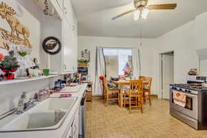 Kitchen featuring appliances with stainless steel finishes, white cabinetry, ceiling fan, and sink