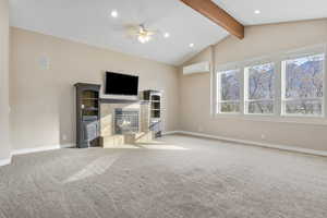 living room with a wall mounted air conditioner, ceiling fan, vaulted ceiling with beams, and light carpet