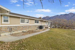 Exterior space featuring central AC, a mountain view, and a front lawn