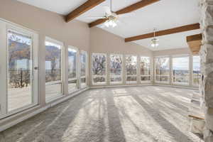 Unfurnished sunroom with lofted ceiling with beams and ceiling fan