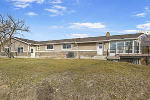 Back of house featuring a yard and central AC unit