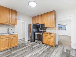 Kitchen featuring sink, light wood-type flooring, and stainless steel appliances