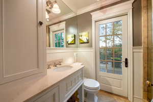 Bathroom featuring vanity, toilet, and ornamental molding