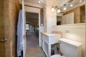 Bathroom with tile patterned floors, vanity, toilet, and ornamental molding