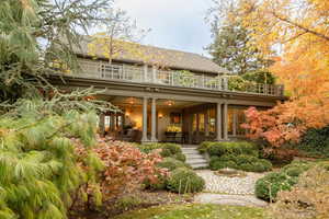 Back of property with ceiling fan and a balcony