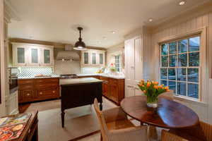 Kitchen with stainless steel appliances, wall chimney exhaust hood, pendant lighting, and ornamental molding