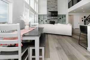 Dining space featuring hardwood / wood-style floors, plenty of natural light, and a towering ceiling