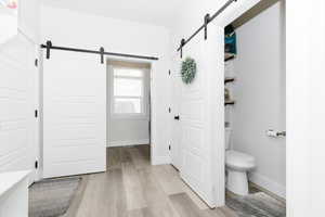 Bathroom with hardwood / wood-style floors and toilet