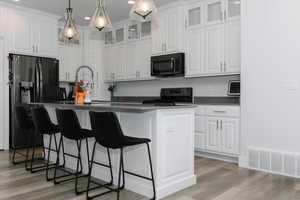 Kitchen featuring white cabinetry and black appliances