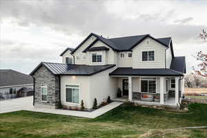 View of front of house featuring covered porch and a front yard