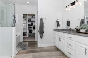 Bathroom featuring a shower, vanity, and wood-type flooring