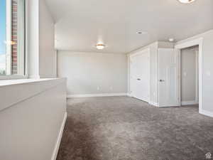 Unfurnished room featuring dark carpet