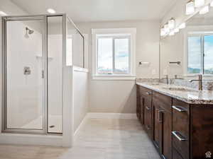 Bathroom featuring plenty of natural light, vanity, and a shower with shower door