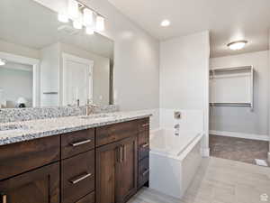 Bathroom featuring vanity, ceiling fan, and a tub