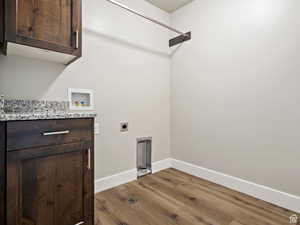 Laundry area featuring cabinets, washer hookup, hardwood / wood-style flooring, and electric dryer hookup