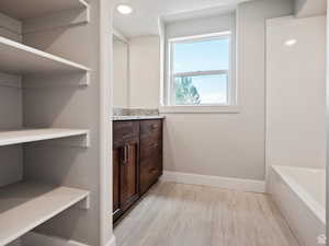 Bathroom featuring a washtub and vanity