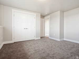 Unfurnished bedroom featuring carpet flooring and a closet