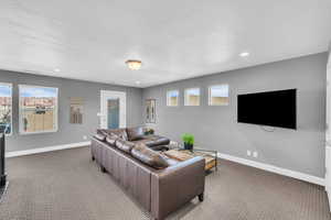 Living room featuring a healthy amount of sunlight, light colored carpet, and a textured ceiling