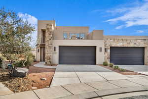 Pueblo-style home with a balcony and a garage