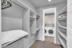 Spacious closet with wood-type flooring and independent washer and dryer