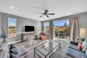 Living room with carpet, plenty of natural light, and ceiling fan