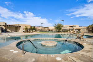 View of swimming pool featuring a patio and a hot tub