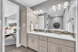 Bathroom with hardwood / wood-style floors, vanity, and backsplash