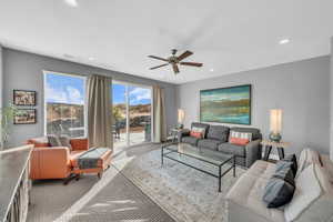 Living room with ceiling fan and light colored carpet