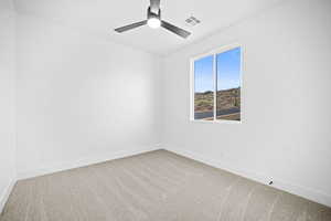 Carpeted empty room featuring ceiling fan