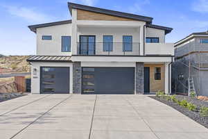 Contemporary home featuring a balcony and a garage