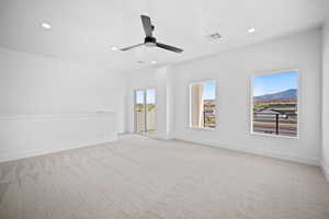 Carpeted empty room featuring ceiling fan