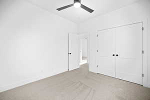 Unfurnished bedroom featuring light carpet, a closet, and ceiling fan