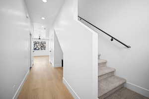 Stairway with ceiling fan and hardwood / wood-style flooring