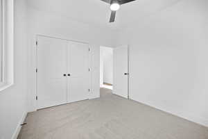 Unfurnished bedroom with a closet, light colored carpet, and ceiling fan