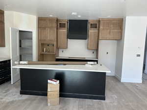 Kitchen with light hardwood / wood-style floors, a textured ceiling, and a kitchen island