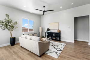 Living area with ceiling fan, wood finished floors, recessed lighting, and baseboards