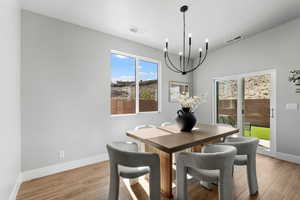 Dining space with a chandelier, light wood finished floors, and baseboards