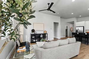 Living area featuring ceiling fan, recessed lighting, light wood finished floors, and baseboards