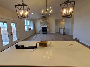 Unfurnished living room featuring a fireplace, wood-type flooring, and french doors