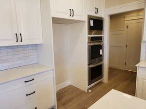 Kitchen featuring white cabinetry, dark hardwood / wood-style flooring, and stainless steel appliances