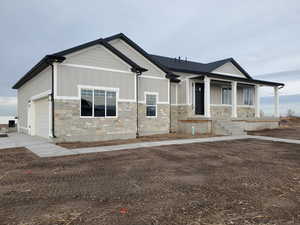 View of front of property featuring a porch and a garage