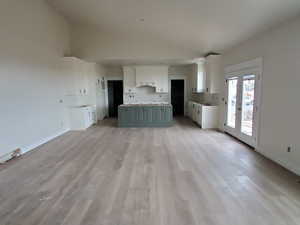 Kitchen with french doors, light wood-type flooring, gray cabinets, and white cabinetry