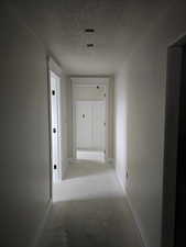 Hallway featuring a textured ceiling