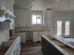 Kitchen with white cabinets, hardwood / wood-style flooring, and a wealth of natural light