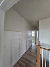 Hall with a textured ceiling and dark wood-type flooring