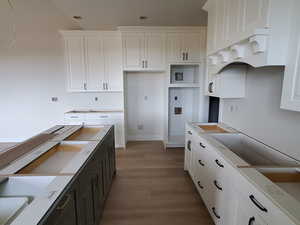 Kitchen featuring white cabinets and wood-type flooring