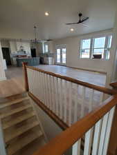 Stairs with french doors, ceiling fan, and hardwood / wood-style floors