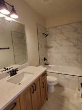 Full bathroom with vanity, toilet, and tiled shower / bath